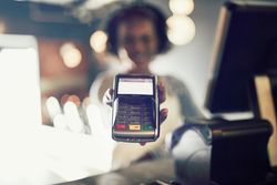 Woman handing over credit card machine