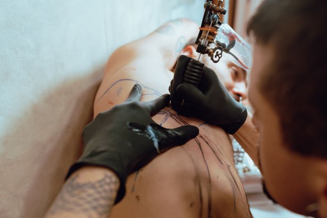 Stylish man drawing tattoo
