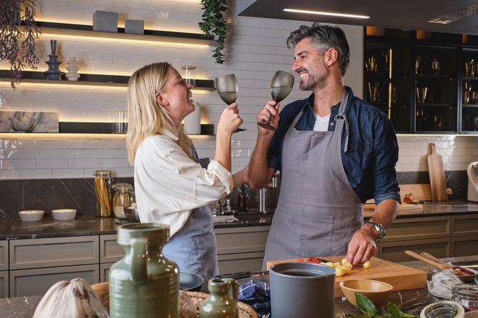 Cheerful funny couple cooking in kitchen