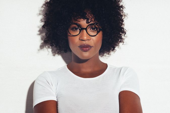 Studio portrait of serious and confident woman wearing round frame glasses