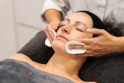Woman having face cleansed during facial