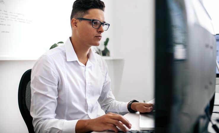 Software developer sitting in front of computer and working in office