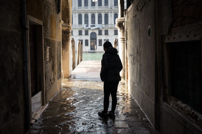 Anonymous woman strolling on rocked alley