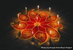 Lit candles on flower shaped carving on floor 476lB5