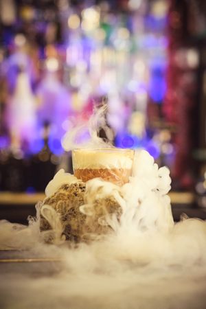 Hot cocktail with steam served on counter in nightclub