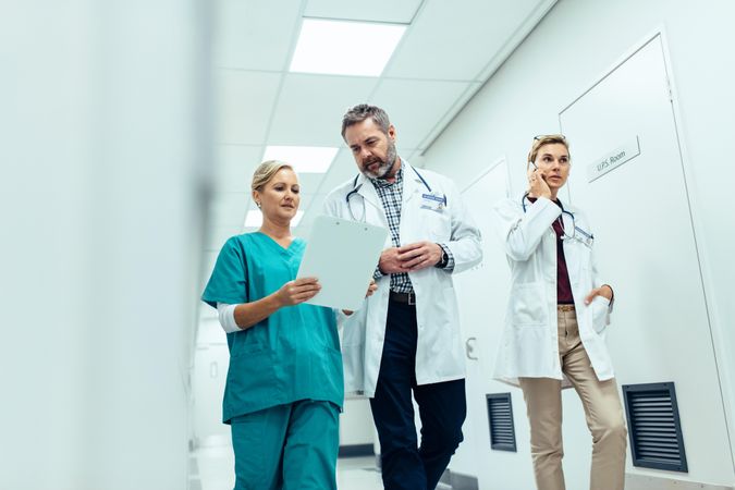 Doctors team walking in hospital corridor indoors