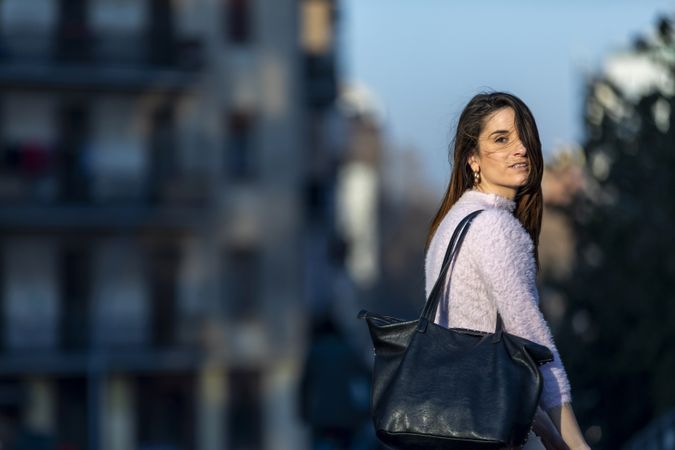 Woman with handbag outside at dusk