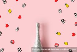 Silver bottle of Champagne on pastel pink background with pop art stickers 5kp6o4