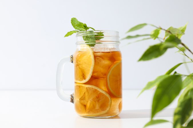 A glass of delicious cold tea on a plain background