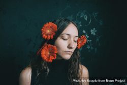 Studio portrait of woman with gerbera flowers on her hair bGQPX5