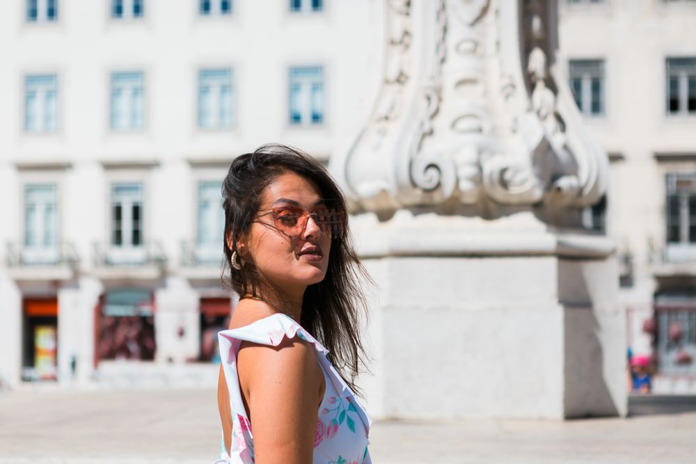 stylish woman in sunglasses sitting in street stairs