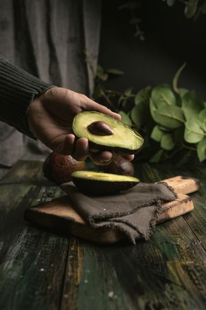 Person hands holding avocados