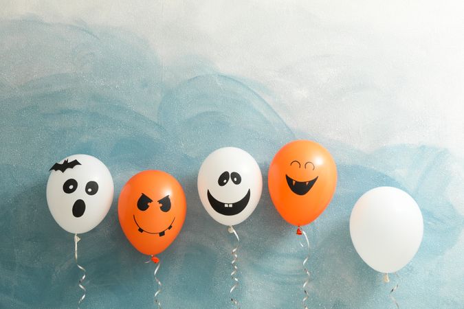Halloween balloons on color background, space for text