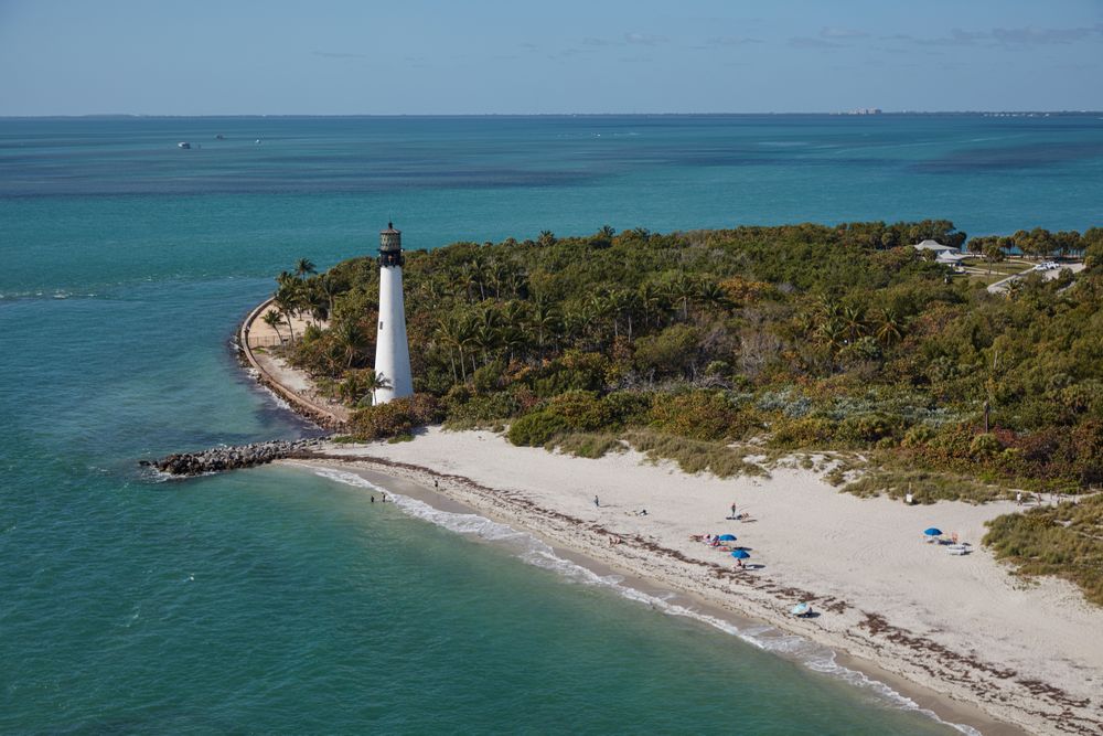 Tropical beach with lighthouse and dense vegetation