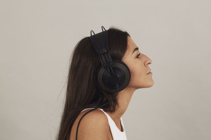 Thoughtful young woman enjoying music in studio