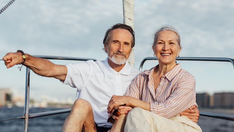 Happy older couple relaxing together on a sailboat