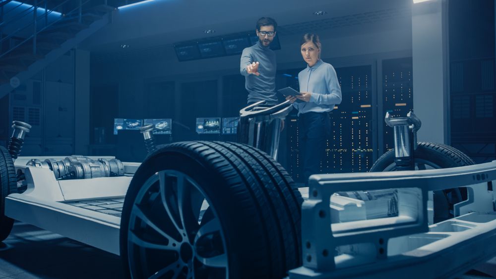 Automobile Mae and Female Design Engineers Working on Electric Car Platform Chassis Prototype, Using CAD Software for 3D Concept