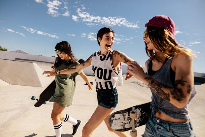 Group of female skaters running and having fun at skate park