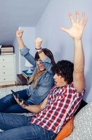 Couple celebrating victory watching sport