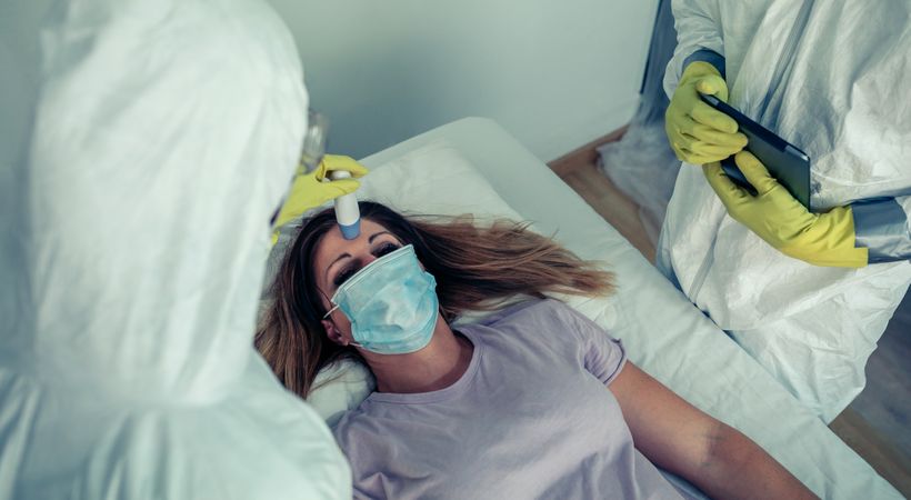 Patient attended by doctors who check if she has fever