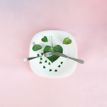 Plate with green leaves hearts and silverware